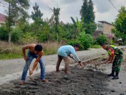 Babinsa Posramil Tripa Makmur bantu ratakan Timbunan Pasir di Halaman Rumah Warga