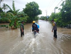 Sinergitas Babinsa Kodim 1404/Pinrang Dan Bhabinkamtibmas Membantu Pengendara Roda Dua Melintasi Jalan Yang Terendam Banjir